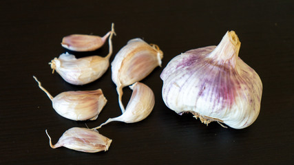 Garlic close-up on a black background. Alternative medicine to SARS-CoV-2 virus. Food protection against viruses, coronavirus, immunity concept.