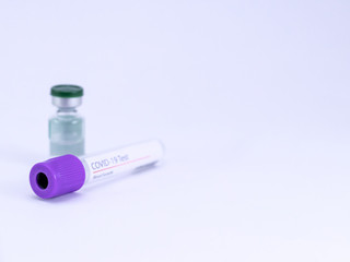 High angle close up shot of Corona virus test sample collecting tube with a vial on white surface.