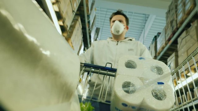 The surge in demand for goods during the epidemic. A man carries toilet paper and groceries in a trolley