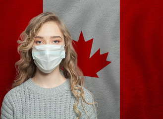 Young woman wearing a face mask with national flag Canada. Flu epidemic and virus protection concept
