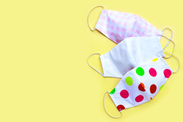 Handmade cloth masks on  yellow background.