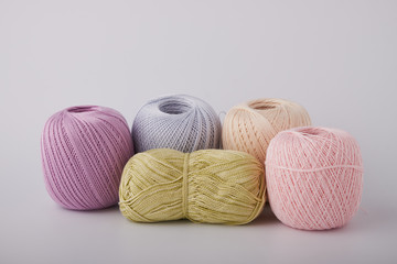 A bright set of knitted flowers. Homemade flowers crochet, multi-colored cotton yarn, crochet hooks on a white background with a copy of the space for text. Easy handmade crochet concept