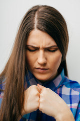 Fototapeta premium Closeup portrait of young beautiful woman thinks bad news head on his hands folded together into fists. Isolated white background.white background. Negative facial expression emotion feelings