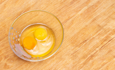 Two chicken eggs, homemade and factory, are broken in a glass plate. Difference concept of homemade natural eggs from store-bought, organic, copy space