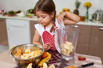 Little girl making a smoothie