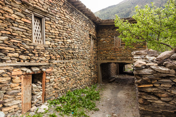 A narrow alley passing through the stone walls of ancient houses in the Himalayan village of Tukuche on the Annapurna Circuit in Nepal.