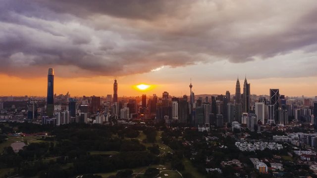 4k Establishing b-roll aerial dramatic sunset with rolling clouds. Drone moving forward towards Kuala Lumpur city skyline.