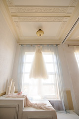 Bridesmaid wedding dress hanging on the window
