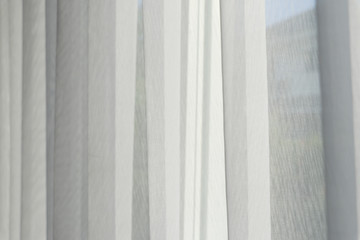 White airy curtains in living room background.