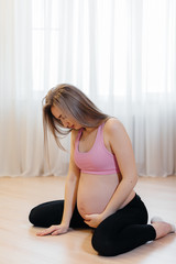 Fototapeta na wymiar A pregnant girl became ill during yoga classes at home. Healthy lifestyle.