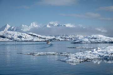 Fototapeta na wymiar Fishing boat sailing among beautiful mountains. winter landscape in lofoten islands in svolvaer city north of norway. fishing season