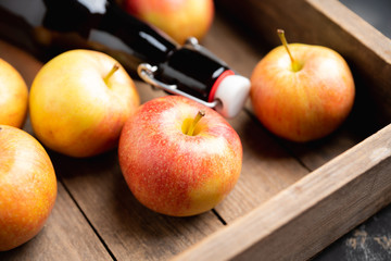 Apple cider in dark bottle made of own farm apples. Selective focus. Shallow depth of field.