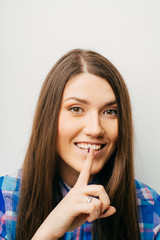 Fototapeta premium long-haired beautiful girl showing quietly finger, isolated on white background