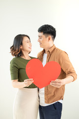 Fototapeta na wymiar Smiling loving couple holding heart shape over white background.
