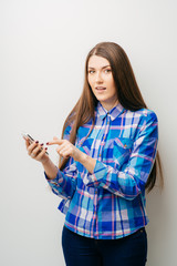 Fototapeta premium young woman typing on mobile phone on white background