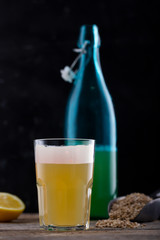 Homemade craft beer in a glass and a bottle, dark wooden background