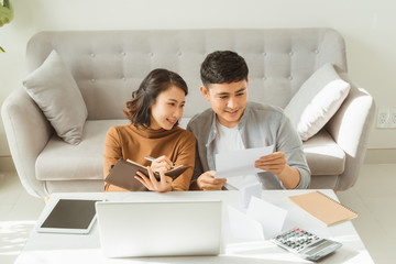 Happy couple with laptop spending time together at home