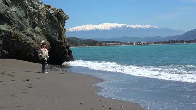 Karatas beach, Fethiye, Turkey - 3d of April 2020: 4K Happy child plays on empty Karatas beach and view on Fethiye
