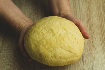 Old women holding dough in hands