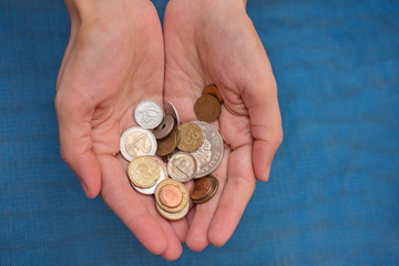 Retro coins from various countries of the world in the hands of a young woman