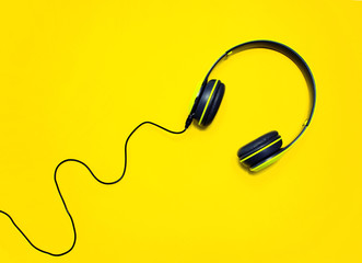 Modern headphones on a yellow background. Music lover concept.