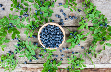 Blueberries in a wooden bowl on a wooden background