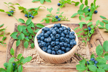 Blueberries in a wooden bowl on a wooden background