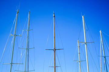 mast from different ships against blue sky