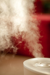 White humidifier on red background. Vertical photo