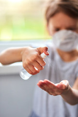 Little girl wear hygienic mask and press alcohol spray to protect, sanitizing.