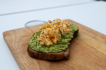 whole wheat toast with guacamole and omelette on top of a wood