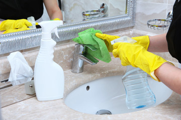 Employee of a cleaning service to clean the faucets in the bathroom.