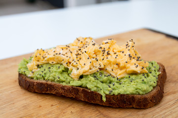 whole wheat toast with guacamole and omelette on top of a wood