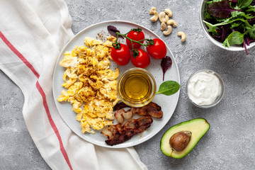 Keto products: eggs, avocado, tomatoes, olive oil, nuts, bacon, cream. Healthy fats concept. Healthy keto breakfast