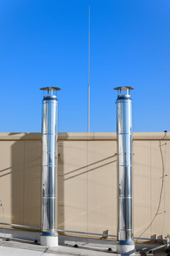 Two stainless steel chimneys on the roof with a lightning catch in the middle.