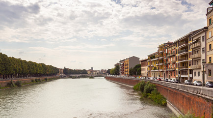 View  from the bridge to the Adige rive and embankments from two sides in Verona city, Italy.