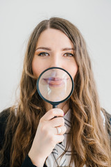 Girl with a magnifying glass in front of her mouth