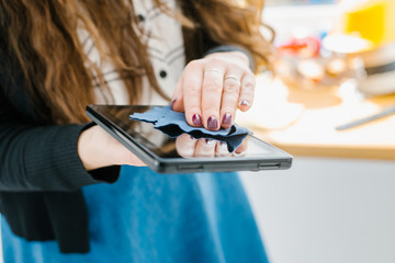 woman hands cleaning a tablet with a napkin