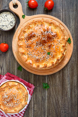 Cabbage pie. Tasty freshly baked homemade vegetable pie with cabbage, spinach, eggs and sesame seeds on a wooden board. Top view.