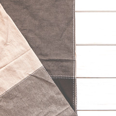 A multi-colored cloth napkin rests on a white wooden background