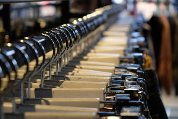 Obraz premium close up a row of many hangers in clothing shop. Blur background