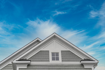 Gable with gray shake and shingle siding, double hung attic window white frame, triangle bracket at...