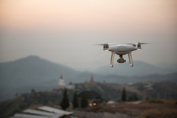 drone with the professional camera takes pictures of the misty mountains at sunset.