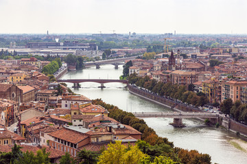 Fototapeta na wymiar View of the Adige River and the old town of Verona from the observation point Punto panoramico Castel S. Pietro located on the square Piazzale Castel S. Pietro in Verona, Italy