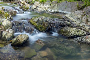 Photo of nature - Long exposure of a mountain stony creek inside in the forest. Small mountain rocky river.