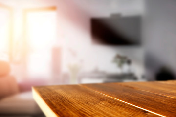 Wooden table in the living room by a sunny window on a warm day