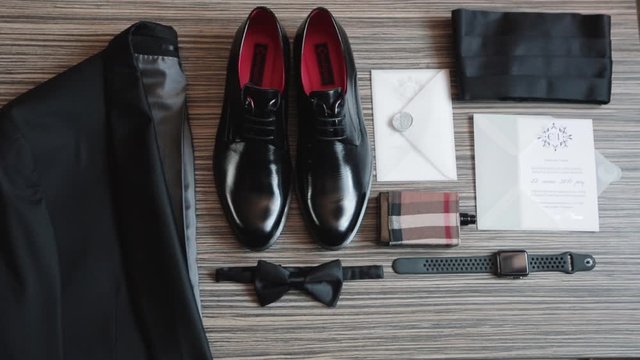 The groom's wedding details are well laid out. Jacket, shoes, invitation, perfume, clock, butterfly