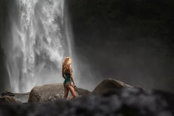 Fototapeten Bali Young traveling blond woman posing near the waterfall in Bali, vacation in Asia.  © frecca