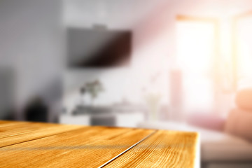Wooden table in the living room by a sunny window on a warm day
