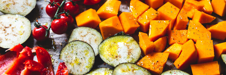Healthy Detox Dinner from different vegetables such as aubergine, red pepper, cherry tomatoes, butternut squash. Slices of Raw vegetables prepared for the roasting, simple family meal, banner size - Powered by Adobe